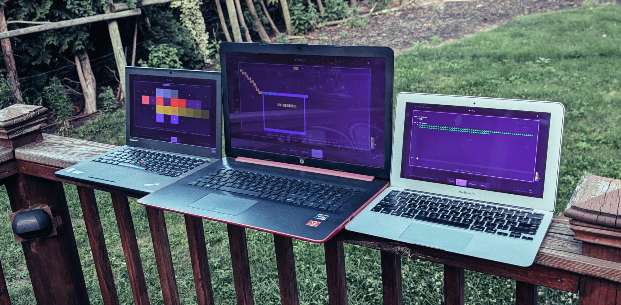 A ThinkPad, an HP, and a MacBook Air side by side on a deck railing, each running a different Purple room
