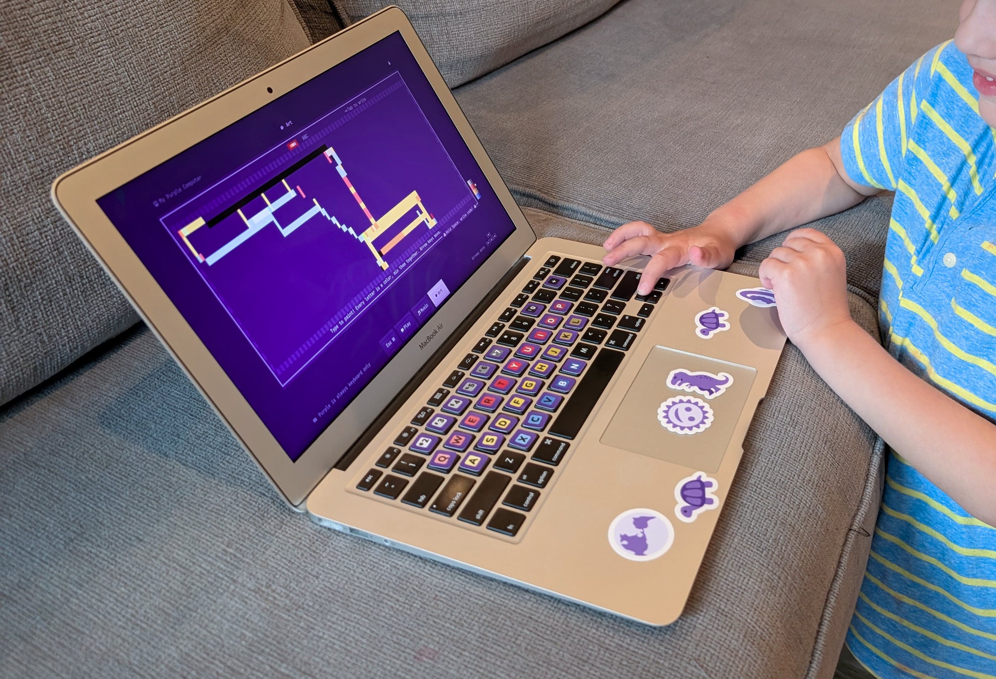 Child using Purple Computer on a couch